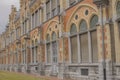 Image of a facade of a building with multiple windows of different shapes and designs