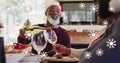 Image of falling snow over african american senior couple deinking wine Royalty Free Stock Photo