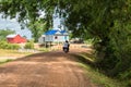 Image of a family in Asia riding a motorcycle in rural countryside Cambodia. Royalty Free Stock Photo