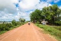 Image of a family in Asia riding a motorcycle in rural countryside Cambodia.