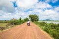 Image of a family in Asia riding a motorcycle in rural countryside Cambodia. Royalty Free Stock Photo