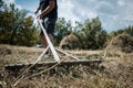 Middle-aged farmer making a haystack with a pitchfork for the winter on a sunny day in autumn. Agricultural work. Hay harvesting Royalty Free Stock Photo