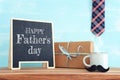 image of fathers day composition with hot cup of coffee and blackboard over table Royalty Free Stock Photo