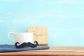 image of fathers day composition with hot cup of coffee over table and blue background Royalty Free Stock Photo