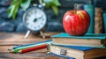 Back to School Essentials: Apple on Piled Books with Pencils and Alarm Clock Royalty Free Stock Photo