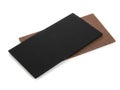 A black rectangular object placed on top of a brown textured surface against a white background Royalty Free Stock Photo