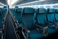 Comfortable and modern airplane cabin interior with empty blue seats Royalty Free Stock Photo