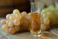 Close-Up of Golden Wine in a Tall Glass Beside Fresh Grapes on a Rustic Wooden Surface - Perfect for Winery and Gourmet Themes