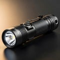 Compact black flashlight on dark surface Royalty Free Stock Photo
