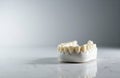 A set of artificial teeth arranged on a smooth surface with a plain background Royalty Free Stock Photo