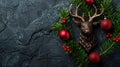 Festive Reindeer Decoration with Fir Branches and Red Bauble on Black Stone - Christmas Concept Royalty Free Stock Photo