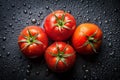 Four Ripe Red Tomatoes with Water Droplets on Dark Textured Surface fresh Royalty Free Stock Photo