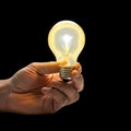 Hand holding light bulb isolated on black background Royalty Free Stock Photo