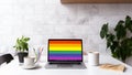 A modern home office setup with laptop and a rainbow flag on screen, for pride day. Generative AI. Royalty Free Stock Photo