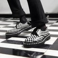 Monochrome Checkered Shoes on Matching Floor: Punk Elegance Meets Ska Cool. Royalty Free Stock Photo