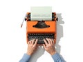 Person typing on orange typewriter, isolated on white background Royalty Free Stock Photo