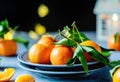Ripe Tangerines on Textured grey plates with Festive Lights