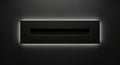 A sleek black rectangular object with glowing light on a dark background Royalty Free Stock Photo