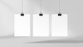 Three Blank White Posters Hanging with Binder Clips on Gray Background Royalty Free Stock Photo