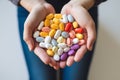 Image of female hands full of colorful pills.