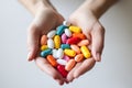 Image of female hands full of colorful pills.