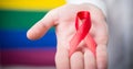 Image of female and male symbols over hand of caucasian man with ribbon