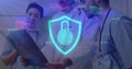 Image of financial data processing and shield icon over diverse doctors in hospital