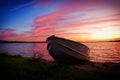 Image of fishing boat on shore of lake at sunset Royalty Free Stock Photo