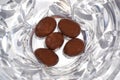 Five chocolate almonds on crystal background