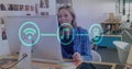 Image of flowchart of icons over caucasian woman picking up cellphone while working on desktop
