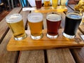 image of four samplers of various types of beer on a wooden base and table Royalty Free Stock Photo