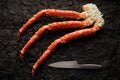 Image of fresh crab phalanges with knife on dark background with copyspace