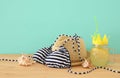 Image of fresh lemonade drink in cute pineapple shape glass with twisted straw next to bikini swimsuit and beach fedora hat over w Royalty Free Stock Photo