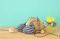 Image of fresh lemonade drink in cute pineapple shape glass with twisted straw next to bikini swimsuit and beach fedora hat over w Royalty Free Stock Photo