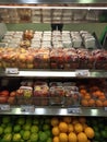 Image of freshly packaged apples and oranges on grocery shelf