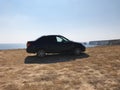 The image in front of the sports car scene behind as the sun going down with wind turbines in the back Royalty Free Stock Photo