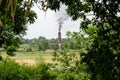 Photo of a furnace emitting black smoke destroying green nature