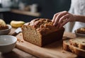 A lady\'s hand cutting the Banana Bread