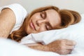 Image of ginger happy woman with freckles sleeping while lying in bed