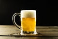 Image of glass tankard full of foamy beer on wooden table, with copy space