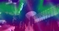 Image of glowing green and blue lights over mid section of caucasian man playing guitar Royalty Free Stock Photo