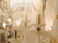 Image of a glowing lamp with white glass fittings and candlelight shades on a gold stand. The concept of the classical style in th Royalty Free Stock Photo