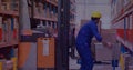 Image of glowing spots of light over caucasian man carrying box working in warehouse, Royalty Free Stock Photo