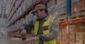 Image of glowing spots of light over caucasian man working in warehouse, Royalty Free Stock Photo