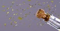 Image of gold confetti with champagne being open on grey background