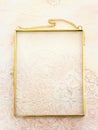 Image of gold tone metal vintage empty photo frame over textured white wooden background. For mockup, can be used for photography Royalty Free Stock Photo