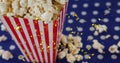 Image of golden confetti over box of popcorn Royalty Free Stock Photo