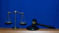 Image of golden scales of justice and hammer for lawyer courtroom on table with blue Royalty Free Stock Photo