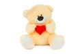 Image of golden toy teddy bear holding red heart and sitting at isolated white background Royalty Free Stock Photo