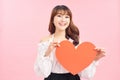 Image of gorgeous lady holding heart shaped paper against pink background